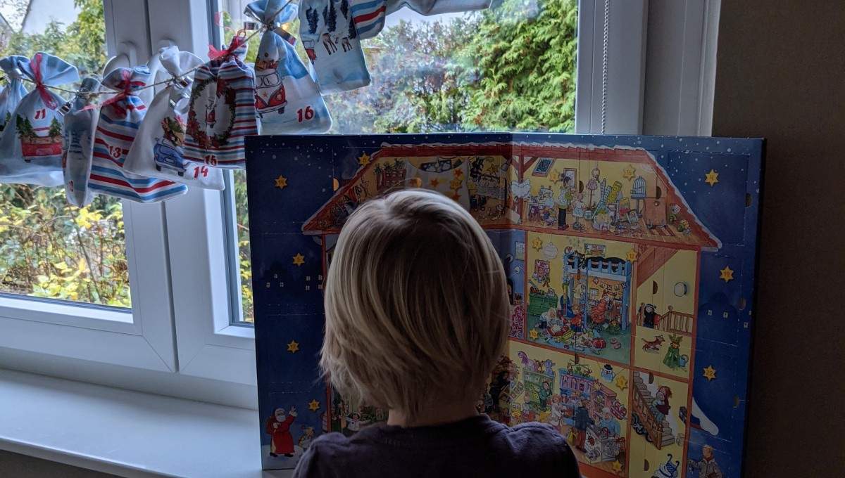 Kind öffnet Adventskalendertür Kind öffnet Adventskalendertür