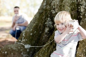 Vater und Sohn spielen Telefon im Garten