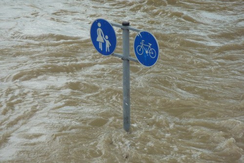 Überflutete Straße mit Straßenschild