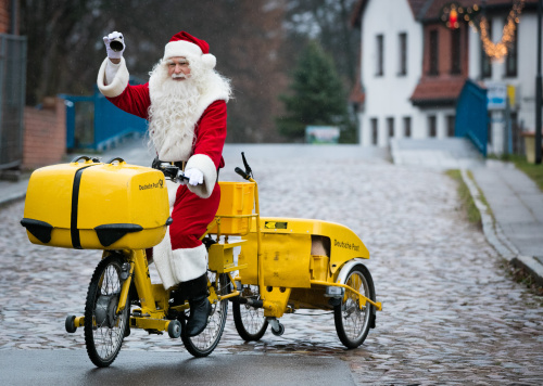 Weihnachtsmann auf einem Post-Fahrrad