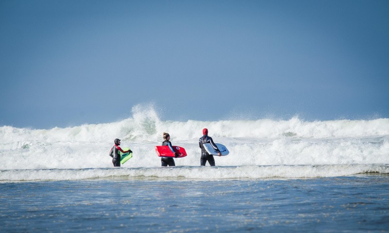 Familie mit Bodyboards im Meer