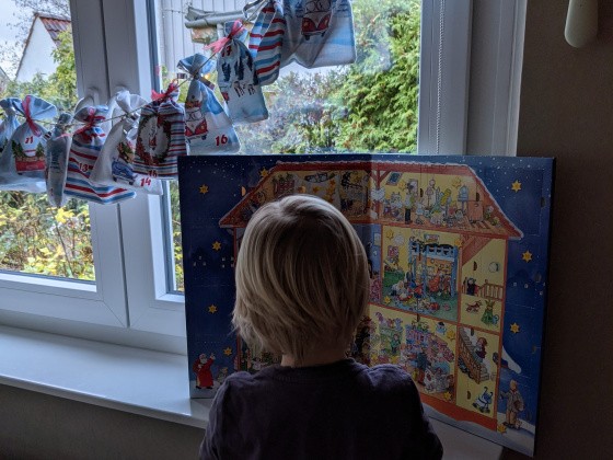 Kind öffnet Adventskalendertür