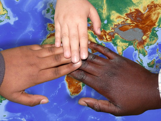 Kinderhände auf Weltkarte