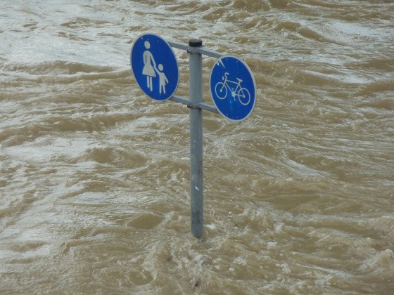 Überflutete Straße mit Straßenschild