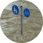 Überflutete Straße mit Straßenschild Überflutete Straße mit Straßenschild