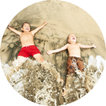 Zwei Kinder liegen am Strand im Spülsaum Zwei Kinder liegen am Strand im Spülsaum