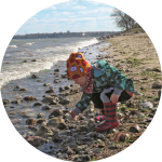 Kind sammelt Steine am Strand