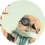Junge mit Fliegerbrille hebt Spielzeugflugzeug in die Luft Junge mit Fliegerbrille hebt Spielzeugflugzeug in die Luft