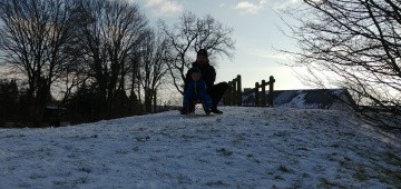 Vater und Sohn auf einem Schlitten am Hang