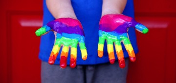 Kinderhände mit Regenbogenfarben bemalt