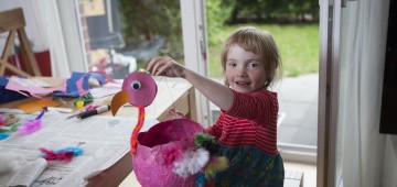 Mädchen hält selbstgebastelte Vogel-Laterne in die Höhe