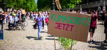 Demonstration mit Schild "Klimaschutz jetzt!"