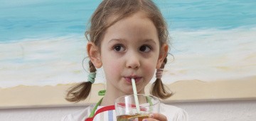 Kind trinkt Eistee aus dem Glas
