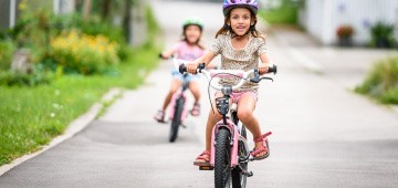 Mädchen fahren im Sommer Fahrrad