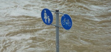 Überflutete Straße mit Straßenschild