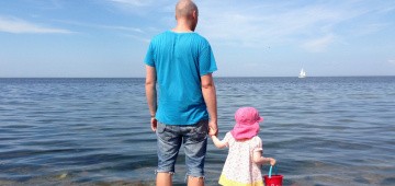 Vater und Tochter blicken auf das Meer