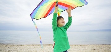 Junge beim Drachensteigen am Strand Junge beim Drachensteigen am Strand