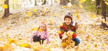 Zwei Kinder spielen mit Laub Zwei Kinder spielen mit Laub