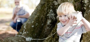 Vater und Sohn spielen Telefon im Garten Vater und Sohn spielen Telefon im Garten