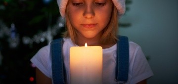 Mädchen hält Kerze in der Hand