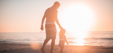 Vater und Kind in der Sonne am Meer Vater und Kind in der Sonne am Meer