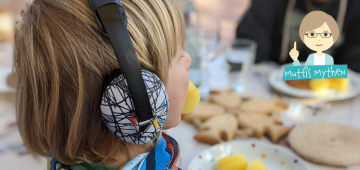 Kind isst Kartoffeln und trägt Gehörschutz