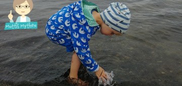 Kind planscht barfuß im Meer