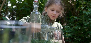 Mädchen gießt Tannenlimo ein Mädchen gießt Tannenlimo ein
