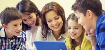 Frau und fünf Kinder lesen auf Tablet Frau und fünf Kinder lesen auf Tablet