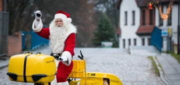 Weihnachtsmann auf einem Post-Fahrrad