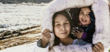 Inuit-Frau mit Kind auf der Schulter