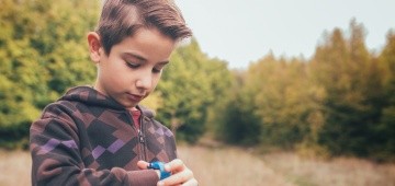 Junge schaut auf seine Armbanduhr Junge schaut auf seine Armbanduhr