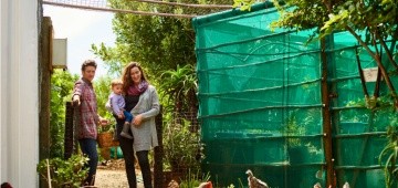 Familie im Garten mit Hühnern